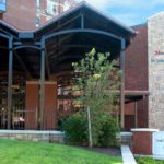 a brown hospital bulding with a green yard. a sign says montefiore st. luke's cornwall